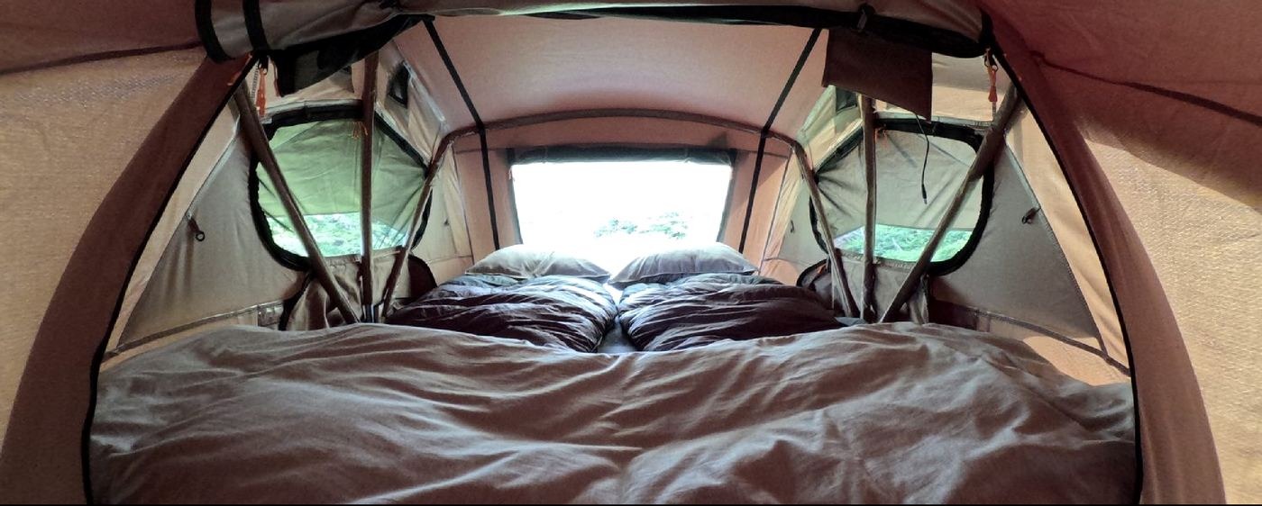 Interior de la carpa Yellow Plum, cama doble con vista al macizo